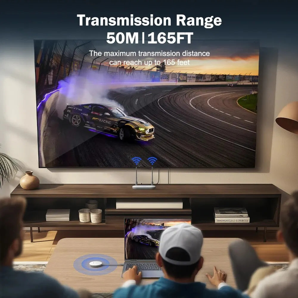 A large wall-mounted TV shows a race car on a track, with text above reading 'Transmission Range 50M | 165FT'. Two people are seated in front of the TV in a living room setting, and a small wireless receiver sits on the console below the screen.