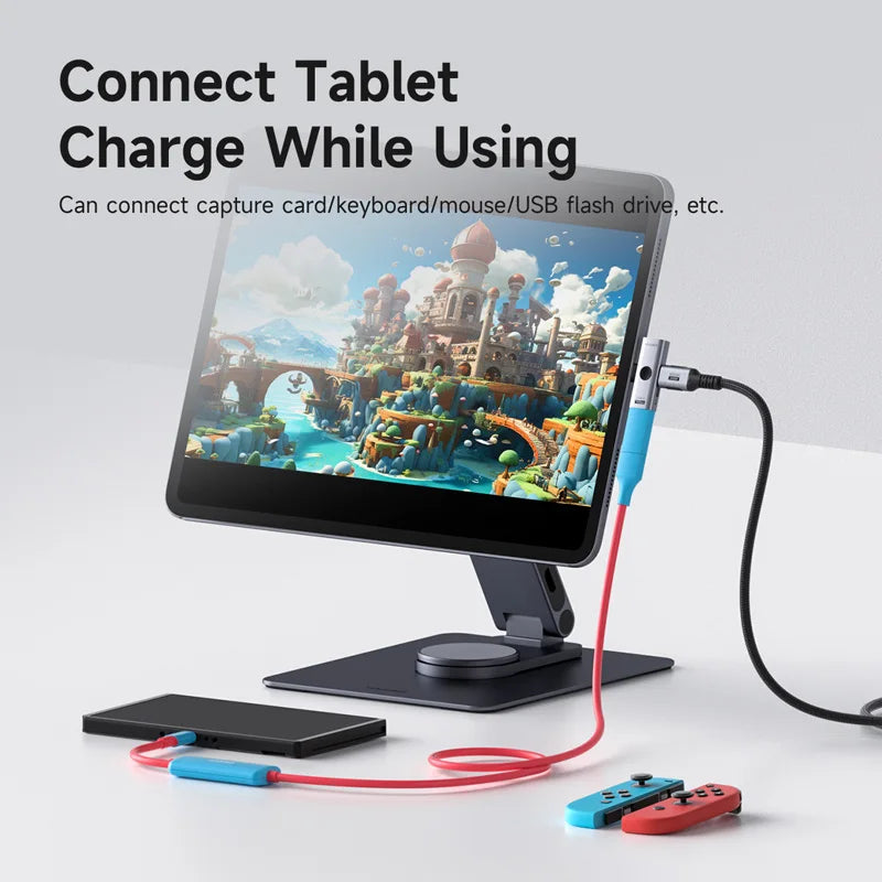Tablet with stand and cables connected, displaying a game on screen.