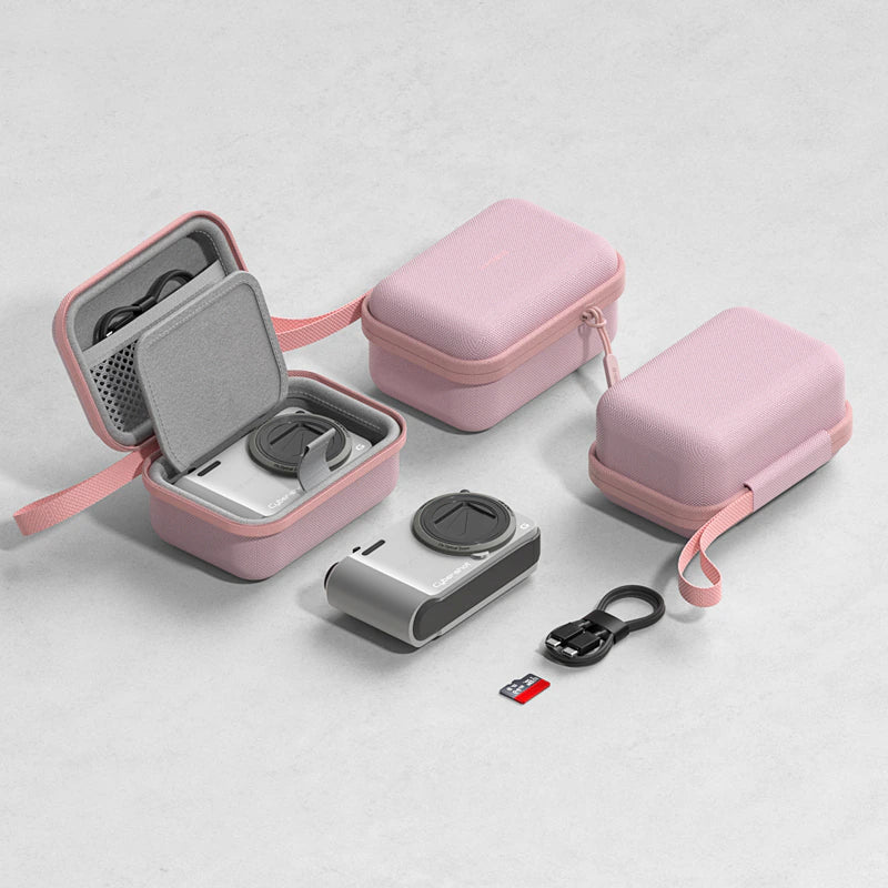 Pink protective camera case set shown on a light gray background, including an open case with a camera inside, a closed case, another closed case with strap, a small black USB cable, and a microSD card.