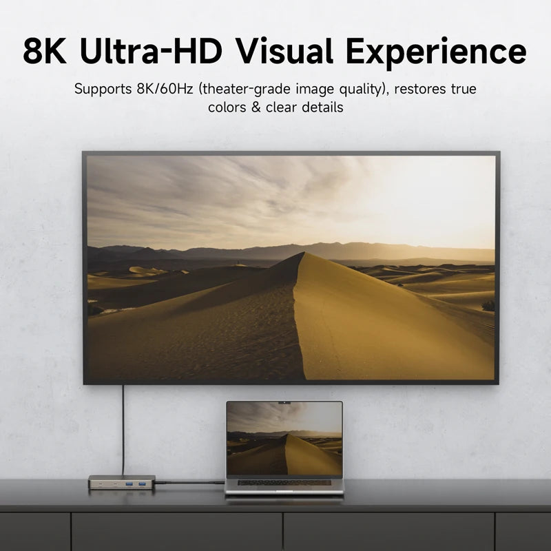 8K Ultra-HD TV displaying a desert landscape with a laptop below on a white wall.
