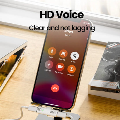 Smartphone on a stand with call interface displayed, placed on a wooden surface with books in the background.