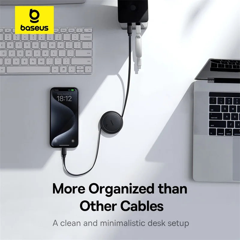 Baseus cable management system on a desk with laptop, phone, and keyboard.