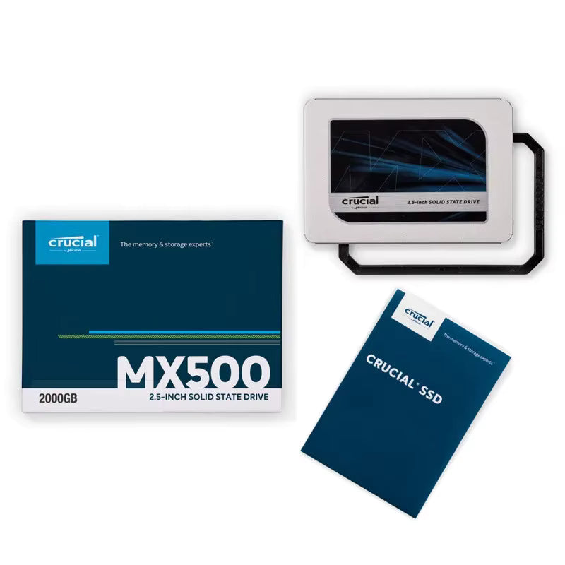 Crucial MX500 2000GB 2.5-inch solid state drive shown with its retail box, the drive itself in a black handle, and a blue product booklet on a white background.
