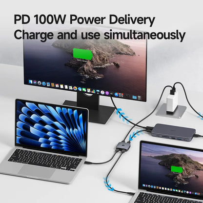 Two laptops and a monitor connected to a power adapter with 'PD 100W Power Delivery' text.